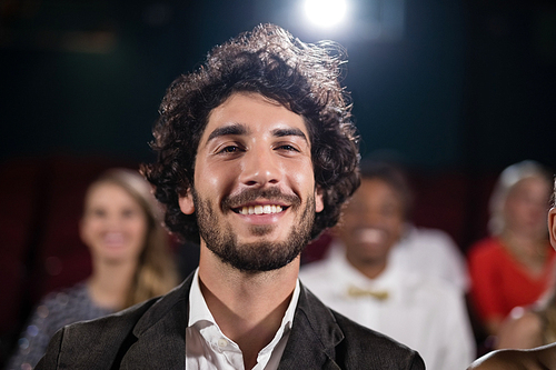 Portrait of man sitting in movie theatre