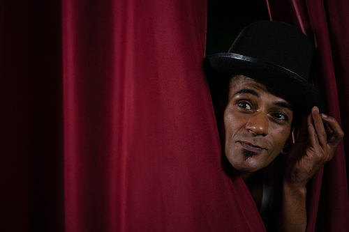 close-up of dance dancer peeking through a stage curtain