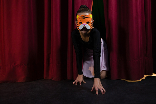 dance dancer wearing mask crawling through the stage curtain