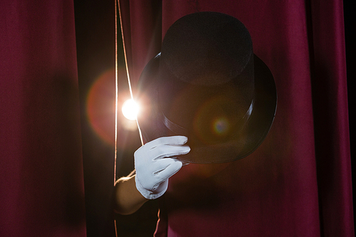 Close-up of hand in a white glove holding hat