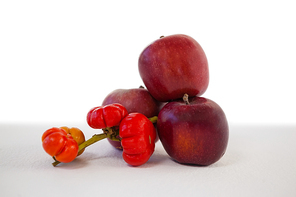 Close-up of red apples and surinam cherry against white background