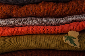 Close-up of woolen stack with autumn leaves