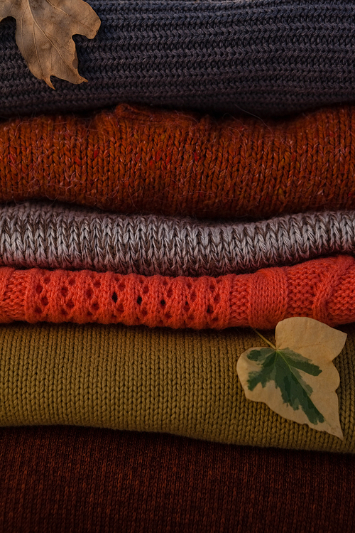 Close-up of woolen stack with autumn leaves
