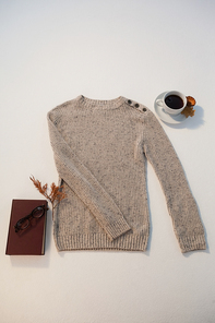 cup of 홍차 with autumn leaves and woolen cloth on white background