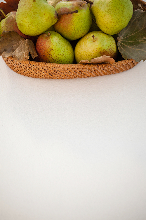 Overhead of pears in wicker basket on white background