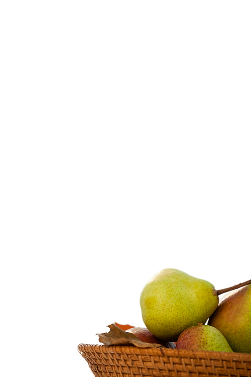 Close-up of pears in wicker basket against white background