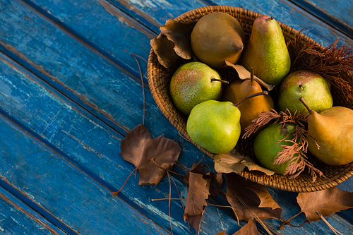High angle view of pears in wicker basket on wooden table