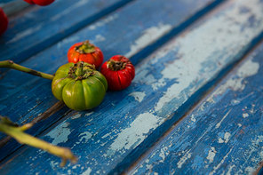 Close up of tiny green and red tomatoes on wooden table