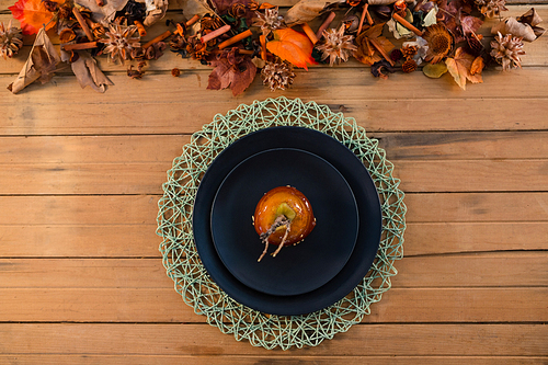 Overhead view of caramelized apple served in plate on wooden table