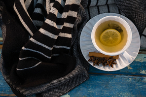 Overhead view of green tea by sweater on wooden table