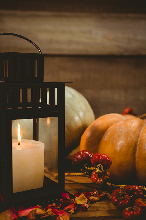 pumpkins and burning candles on table during