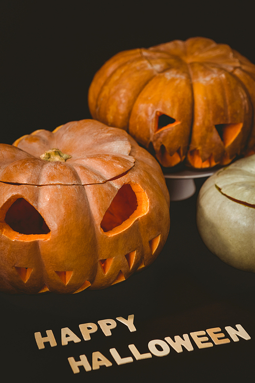 High angle view of happy Halloween text with jack o lanterns over black background