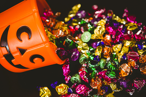 high angle view of bucket with colorful chocolates during halloween over  background