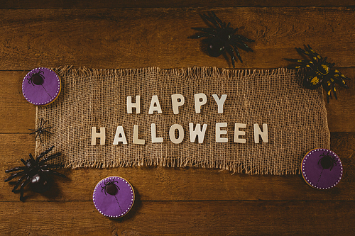 High angle view of happy Halloween text on sack with decorations at table