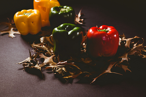 high angle view of carved bell pepper with  leaves on wooden table