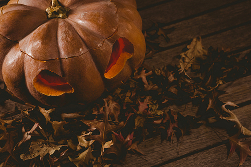 high angle view of jack o lantern with  leaves on table