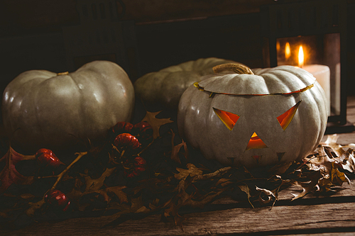 white jack o lanterns with  leaves on wooden table