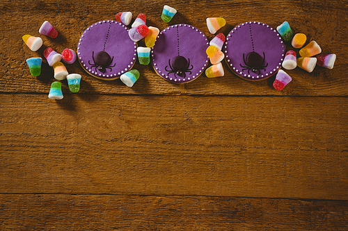 High angle view of Halloween cookies with candies on wooden table