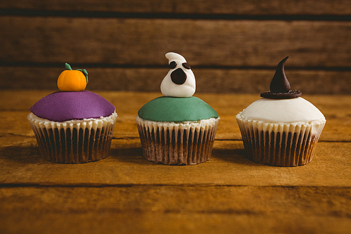 Close up of Halloween cup cakes arranged on wooden table