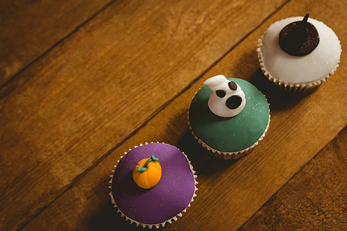 High angle view of Halloween cup cakes arranged on wooden table