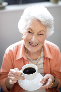 High angle portrait of senior woman holding coffee cup at nursing home