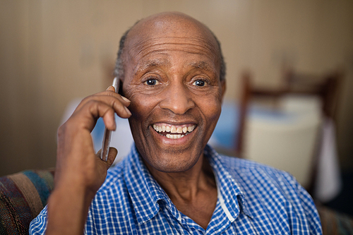Portrait of cheerful senior man talking on mobile phone at nursing home