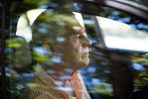 Mature man seen through car window
