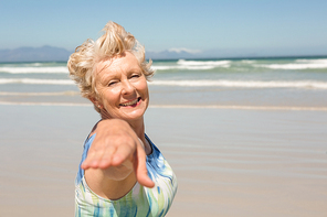 Portrait of smiling senior  woman standing against clear sky at beach