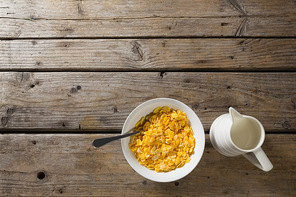 Bowl of wheaties cereal and milk with spoon on wooden table