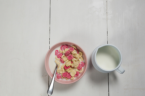 Overhead of honeycomb cereal and milk on wooden table