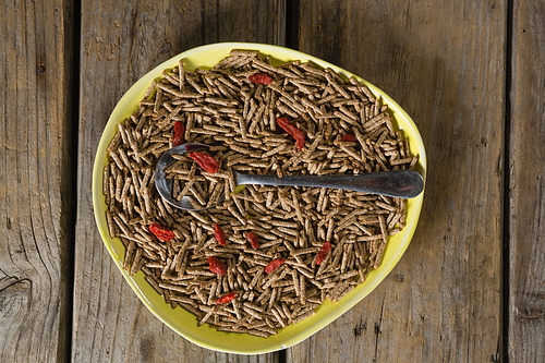 Cereal bran sticks with spoon in plate on wooden table