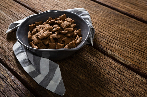 Bowl of chocolate toast crunch with napkin on wooden table