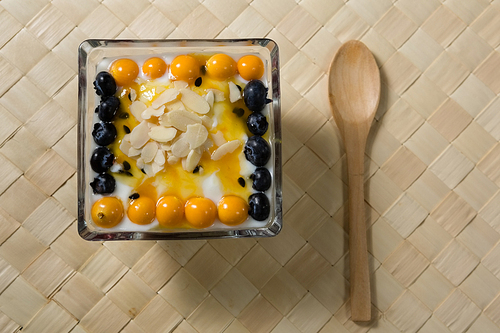 Yogurt with blueberries and golden berries in bowl on placemat