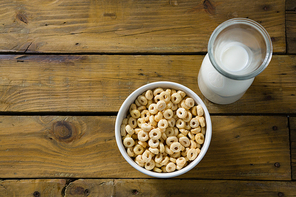 Close-up of cereal rings and milk on wooden table