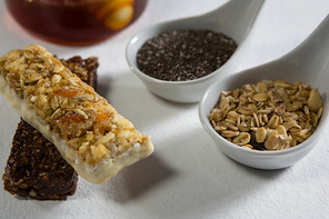 Close-up of granola bar and cereals on white background