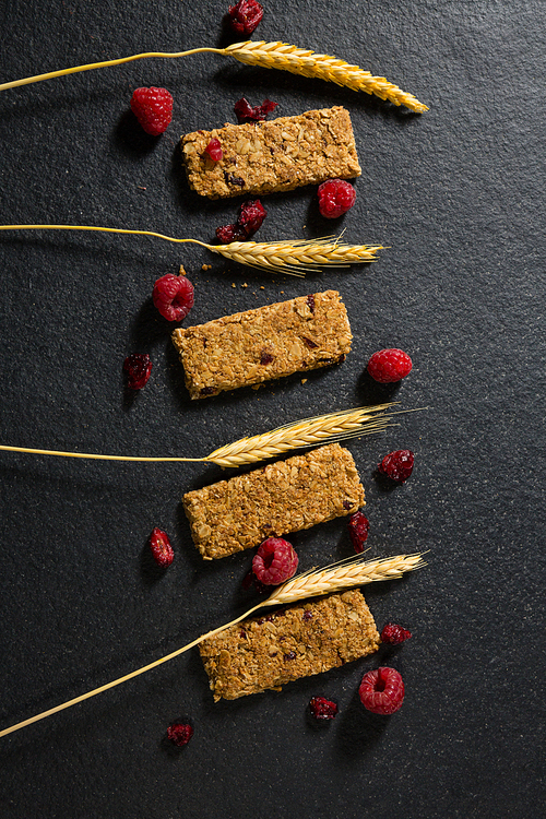 Overhead view of granola bar with fruits on concrete background