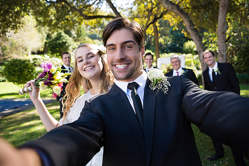 Portrait of happy couple posing in park during wedding