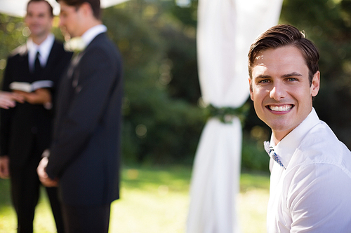Portrait of happy waiter in park during wedding