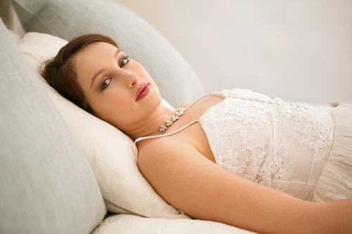 Portrait of beautiful bride relaxing on bed at home