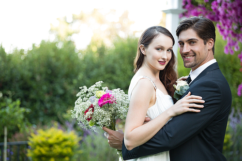Portrait of happy newlywed couple standing in park