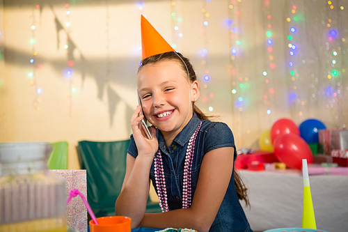 Girl talking on mobile phone during birthday party at home