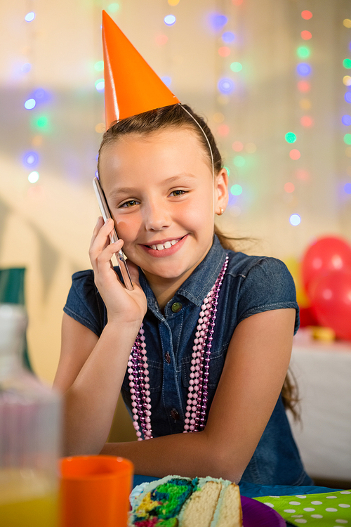 Girl talking on mobile phone during birthday party at home