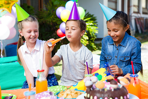 Happy children enjoying birthday party while sitting at table