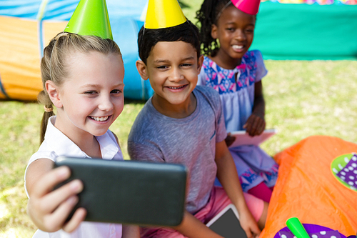 High angle view of children taking selfie during birthday party in yard