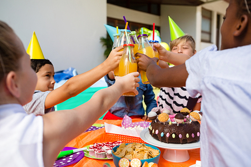 Children toasting juice during birthday party