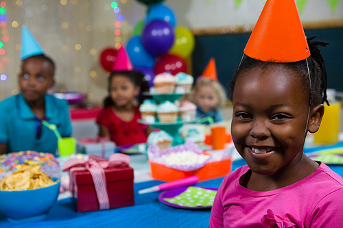 Portrait of girl with friends in background during birthday party