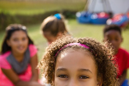 Cropped portrait of girl with friends in background during birthday party