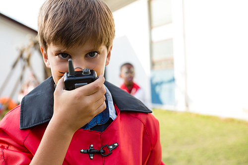 Portrait of boy with face paint using walkie talkie during birthday party