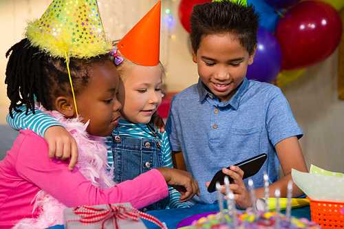 Kids looking at smartphone during birthday party