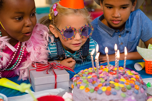 Close up of children looking at birthday cake during party